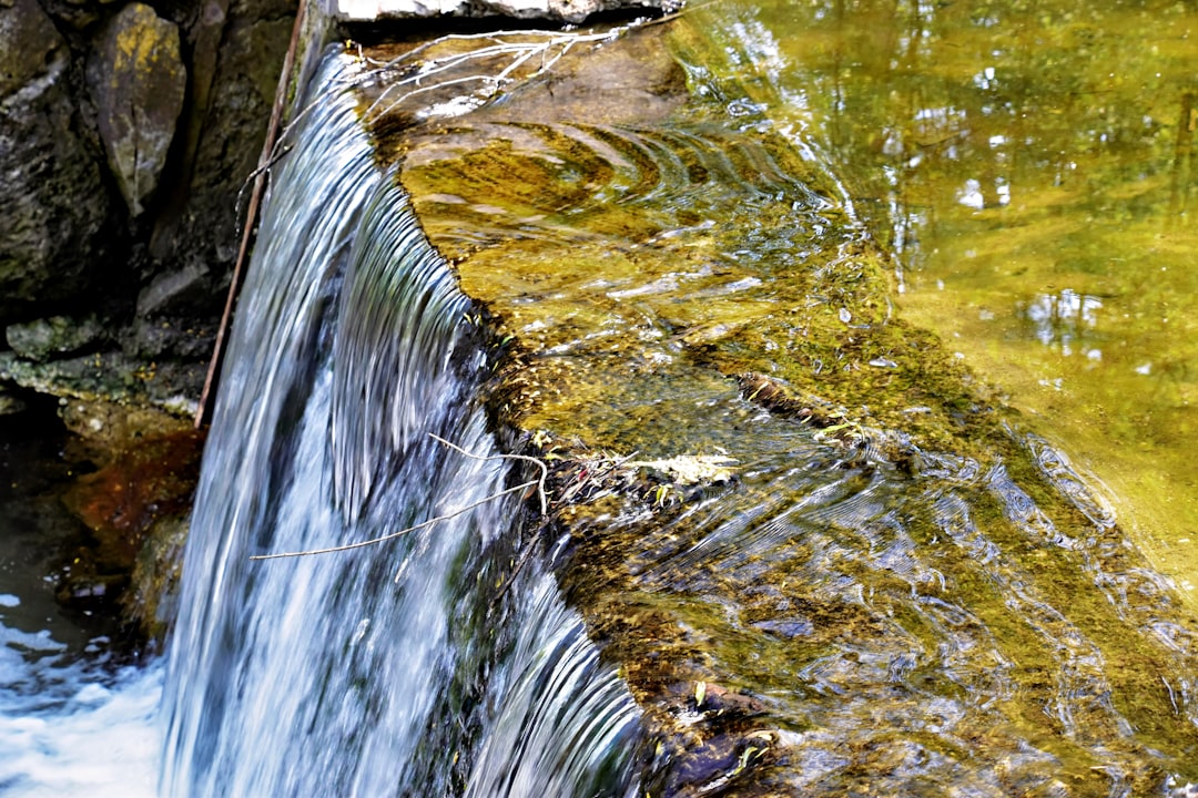 a close up of a small waterfall in a body of water