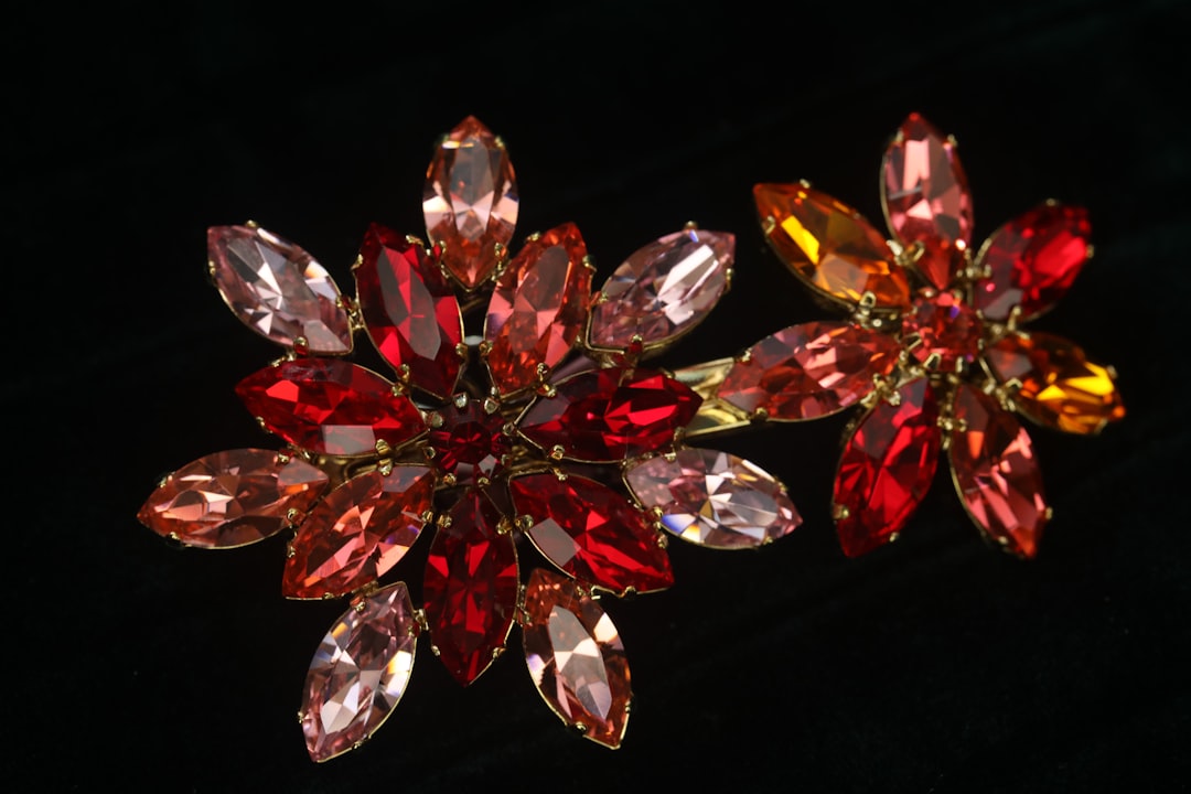 Two floral brooches with red and pink gemstones